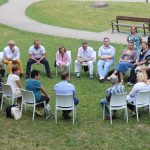 circle of people sitting on chair on grass fiedl